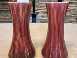 deux vases posés sur une table, avec un mur de pierre en arrière-plan