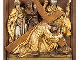 une statue de Jésus portant la croix, entouré d'autres personnes