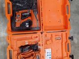 une mallette orange contenant des outils, posée sur un sol en béton
