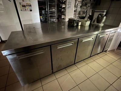 stainless steel counter top in a commercial kitchen with pots and pans on it