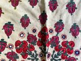 a close up of a table cloth with red flowers on it