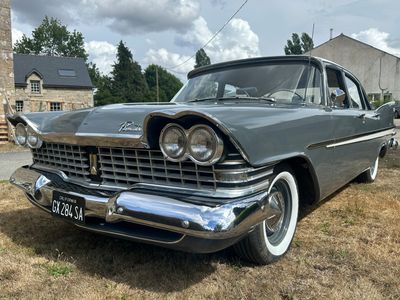 une voiture garée sur la pelouse devant une maison