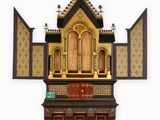 a small wooden shrine with a cross on top of it