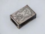 a small silver box with a picture of a woman on it