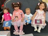 five dolls that are sitting on a chair together