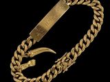 gros plan d'un bracelet en or sur fond noir