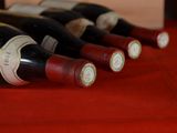 several bottles of wine are lined up on a red table