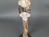 une statue en bois représentant un chat, posée sur un socle noir