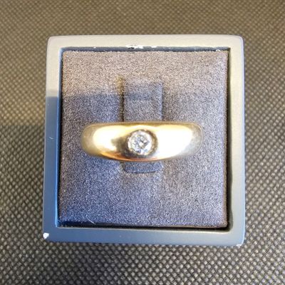 une photo d'une bague en diamant dans un écrin posé sur une table