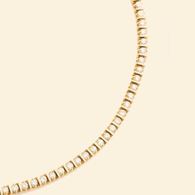 a yellow gold tennis bracelet with diamonds on a white background