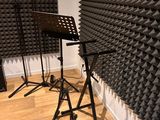 three microphone stands in front of a wall of sound foam