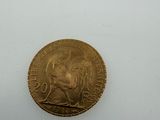 a close up of a gold coin on a white surface