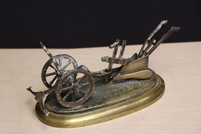 a bronze sculpture of a horse drawn carriage on a table