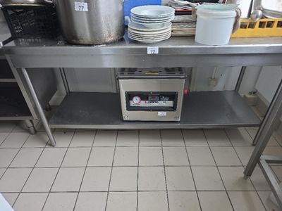 une table en acier inoxydable sur laquelle sont posés de nombreux plats