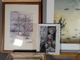 many framed pictures on a shelf in a room