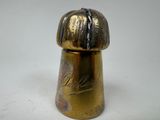 a gold colored salt shaker on a white table