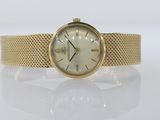 a close up of a gold wrist watch on a white surface