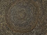 a close up of a black and gold painting on a wall
