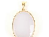a white glass pendant with a gold plated bail