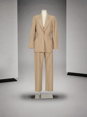 un costume posé sur un mannequin devant un fond gris