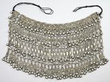 gros plan d'un collier en argent sur une surface blanche