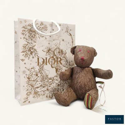 a teddy bear sitting next to a gift bag