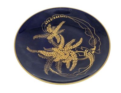une assiette bleue ornée d'un motif doré