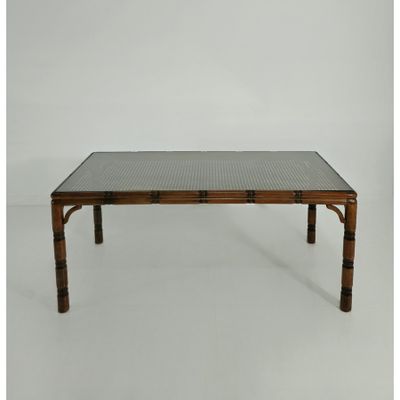 La table est en bambou et possède un plateau en verre.