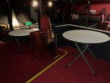 tables and chairs in a room with a stage in the background