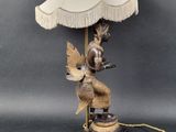 a lamp that is sitting on a table with a bird on it