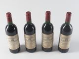 three bottles of red wine are lined up on a white surface