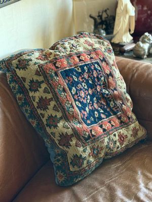 a brown leather couch with a colorful pillow on it