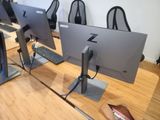 row of computer monitors sitting on top of a wooden table