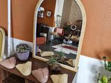 une table avec un miroir et une chaise dans une pièce aux murs orange