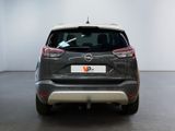 the back end of a grey car in a white room