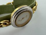 a watch with a chain around it on a white surface