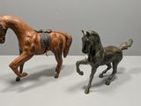 two figurines of a horse and a horse on a table