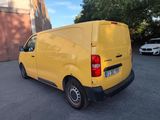 the yellow van is parked in the parking lot next to the building