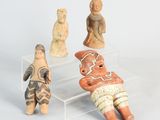 several figurines of people are sitting on a clear shelf