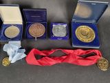 three medals and a red ribbon are sitting on a table