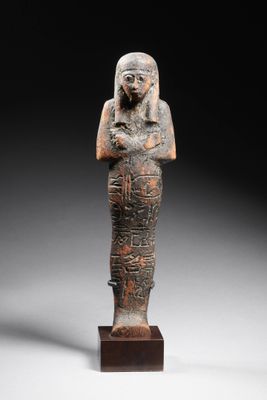 une statue égyptienne représentant une femme tenant un oiseau