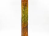 a glass vase with a green and orange design on it