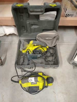 une boîte à outils contenant des outils, posée par terre dans une pièce