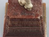 a figurine of a dog sitting on top of a book