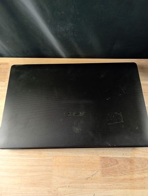 l'arrière d'un ordinateur portable noir posé sur une table en bois