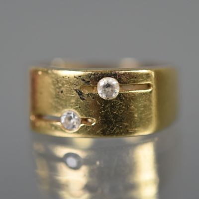 un gros plan d'une bague en or sertie de deux diamants