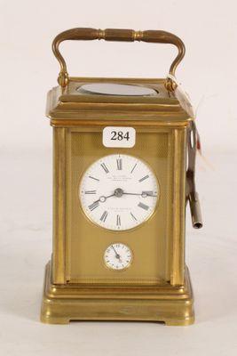 a gold clock that is sitting on a white surface