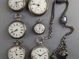 several different types of pocket watches are displayed on a gray surface