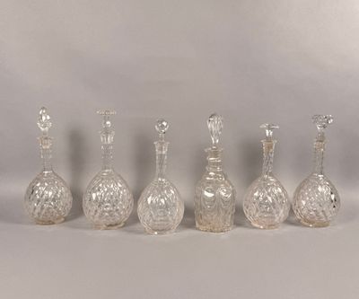 six glass vases are lined up in a row on a white surface