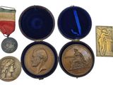 four medals and a medal in a case on a white surface